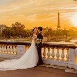 Couple de mariés sur pont devant la tour Eiffel