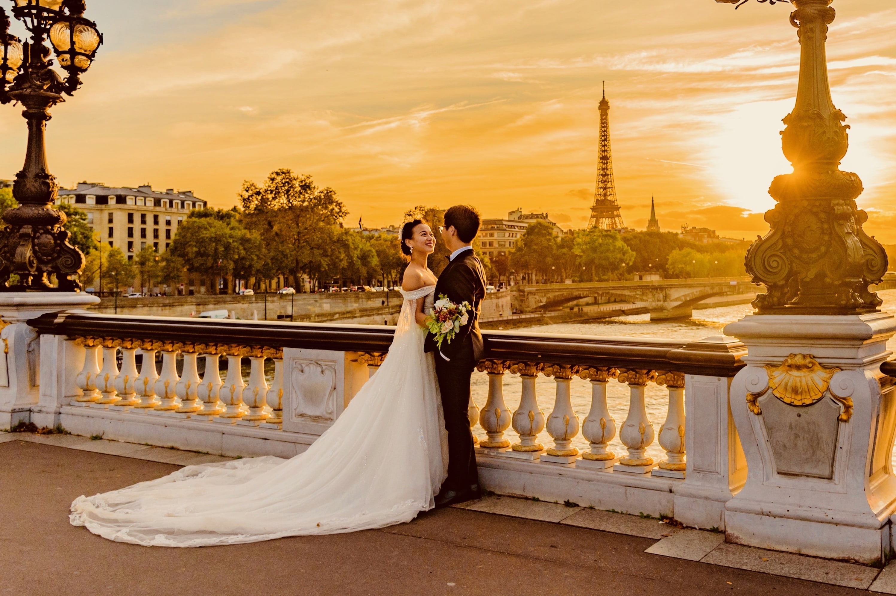 Couple de mariés sur pont devant la tour Eiffel